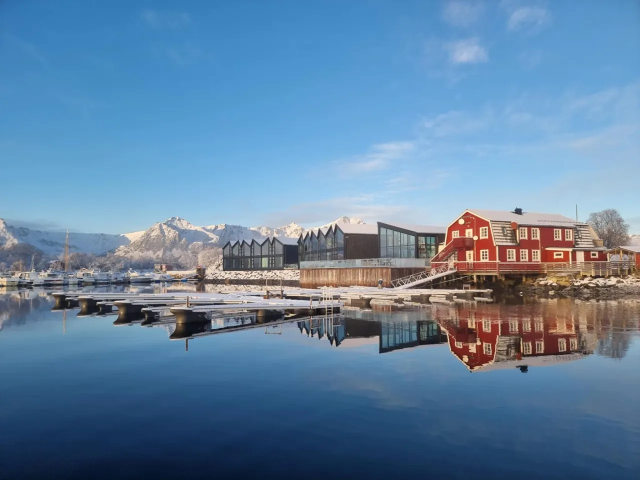 Vinterbilde av Ringstad Resort med blikkstille sjø 